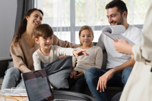 Una familia de cuatro personas todos sonriendo y recibiendo una terapia familiar